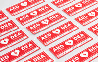 A collage of red rectangular decals that adhere to doors indicating an AED is present at a facility