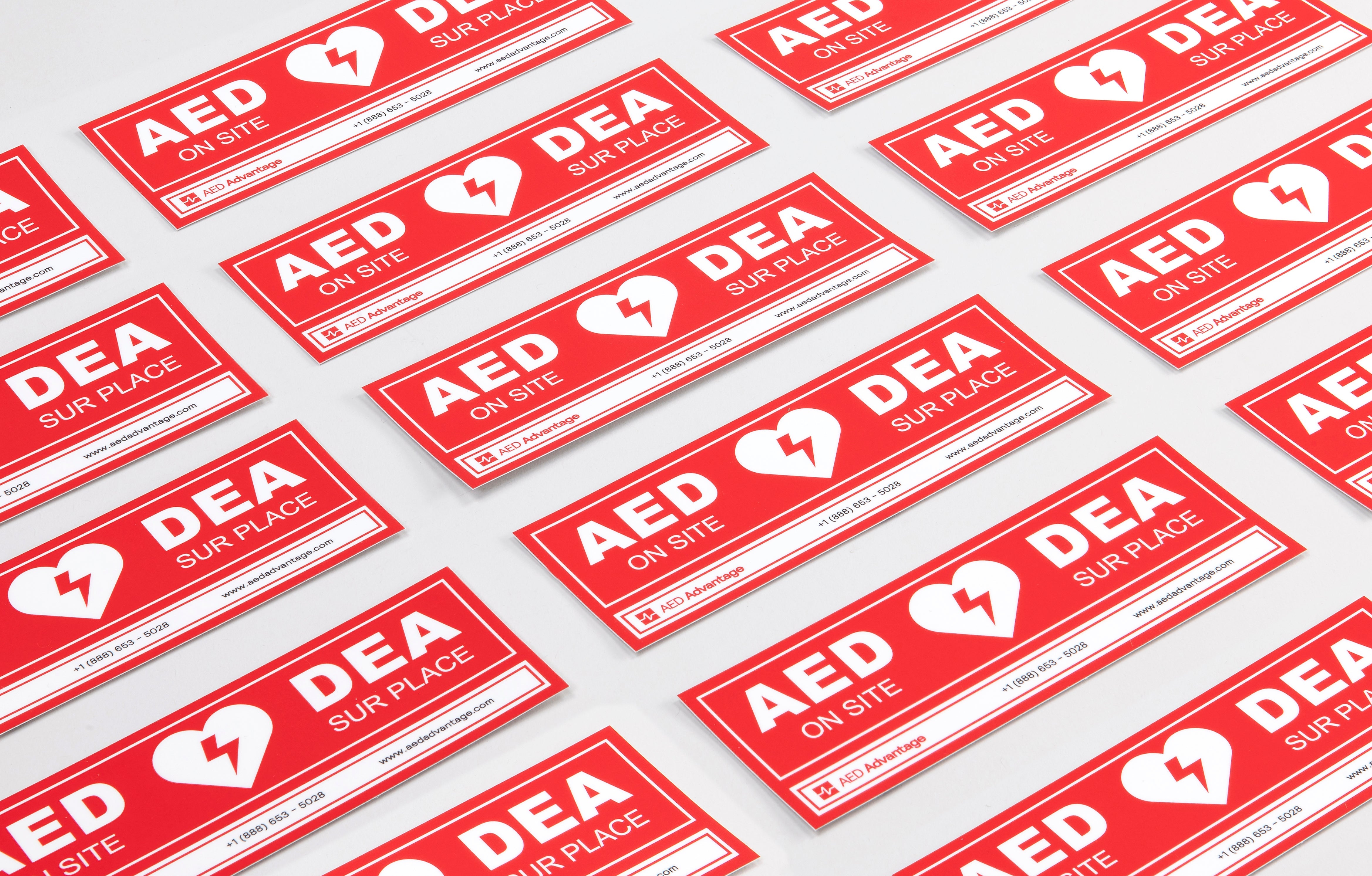 A collage of red rectangular decals that adhere to doors indicating an AED is present at a facility