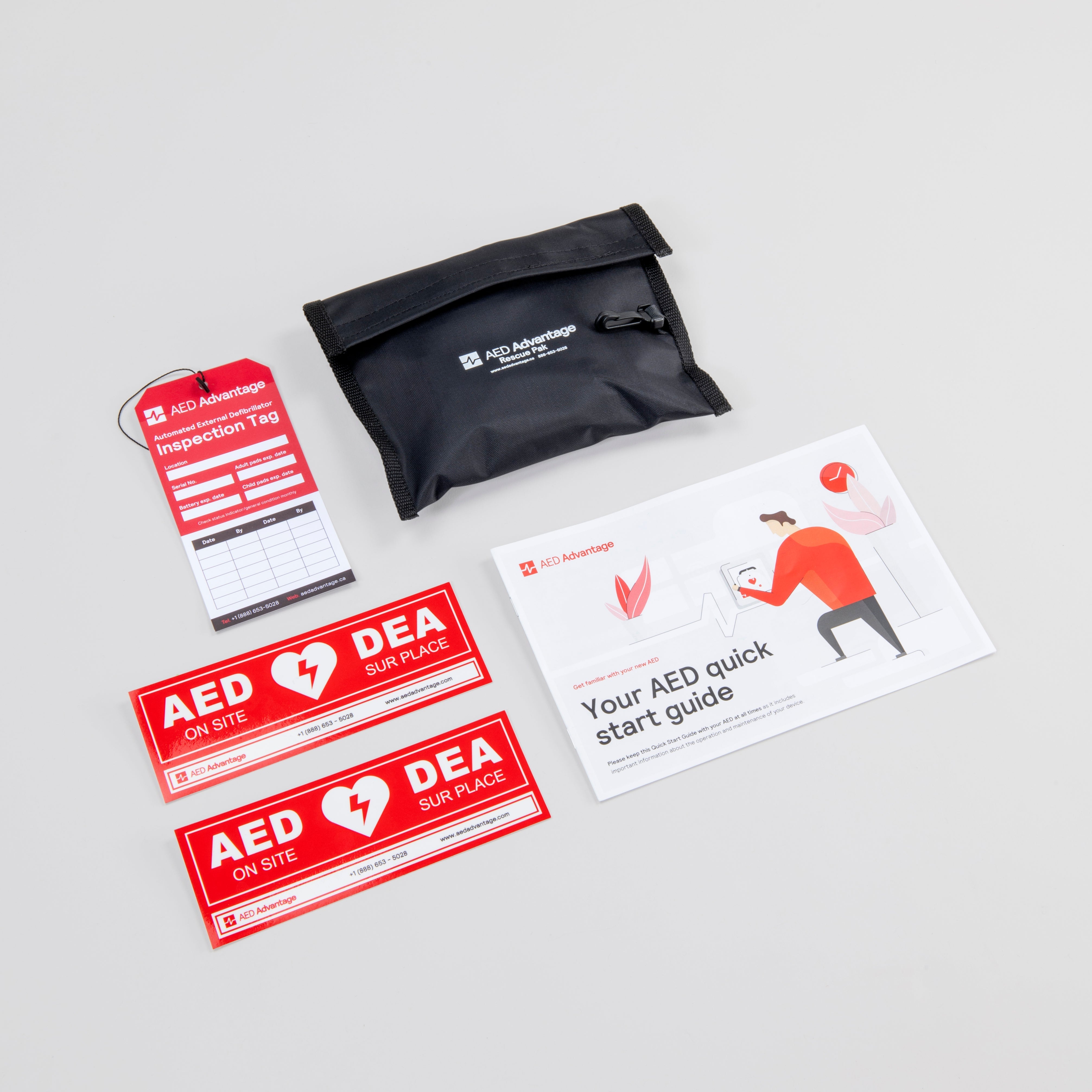 A red AED inspection tag, black rescue kit, two red door decals, and an AED quick start guide booklet