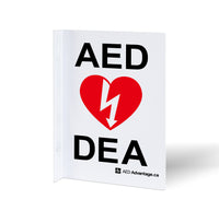 A bilingual white metal rectangular wall sign containing large bold text indicating an AED is present 