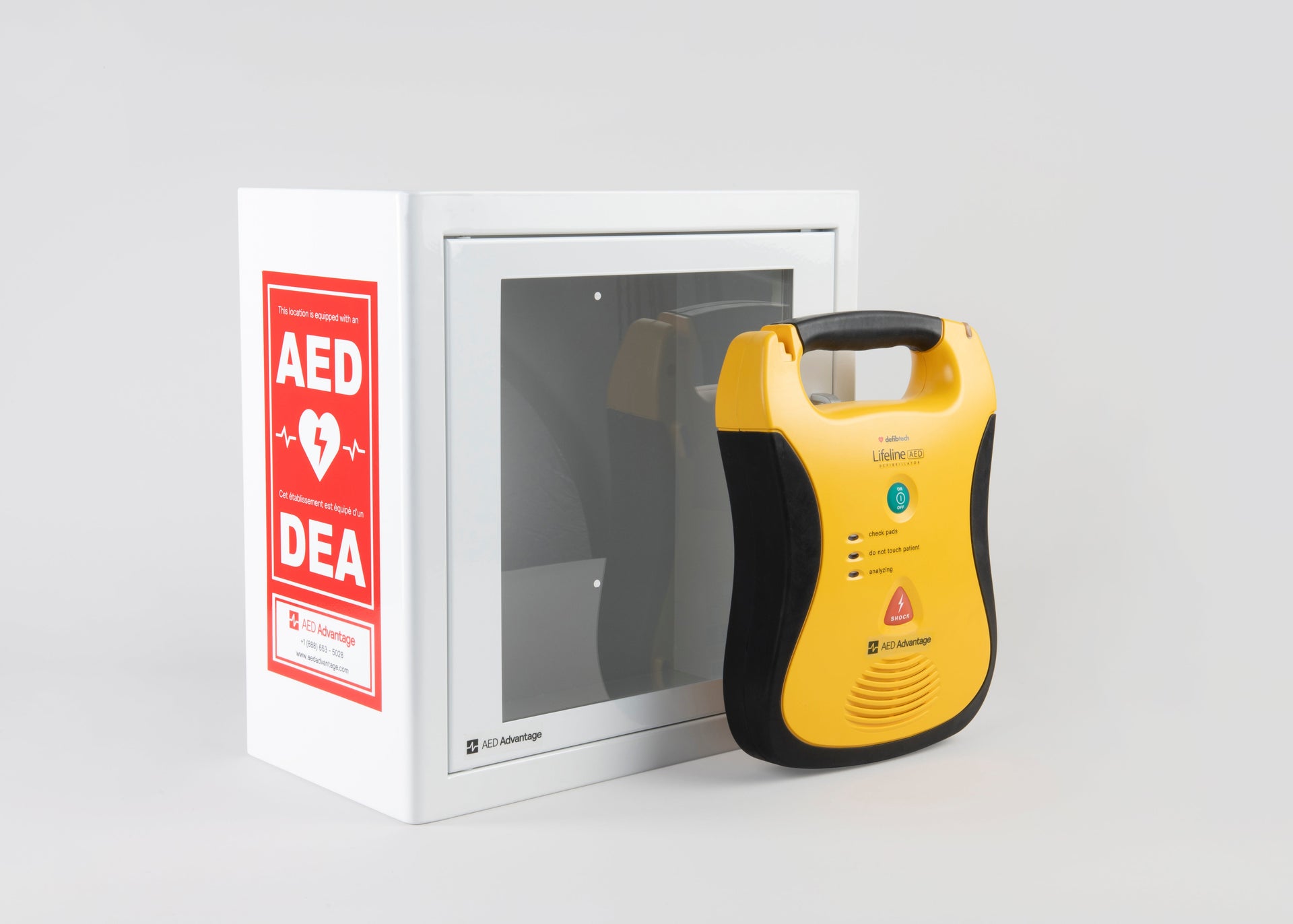 A yellow and black Defibtech Lifeline AED standing in front of a white metal cabinet with red decals