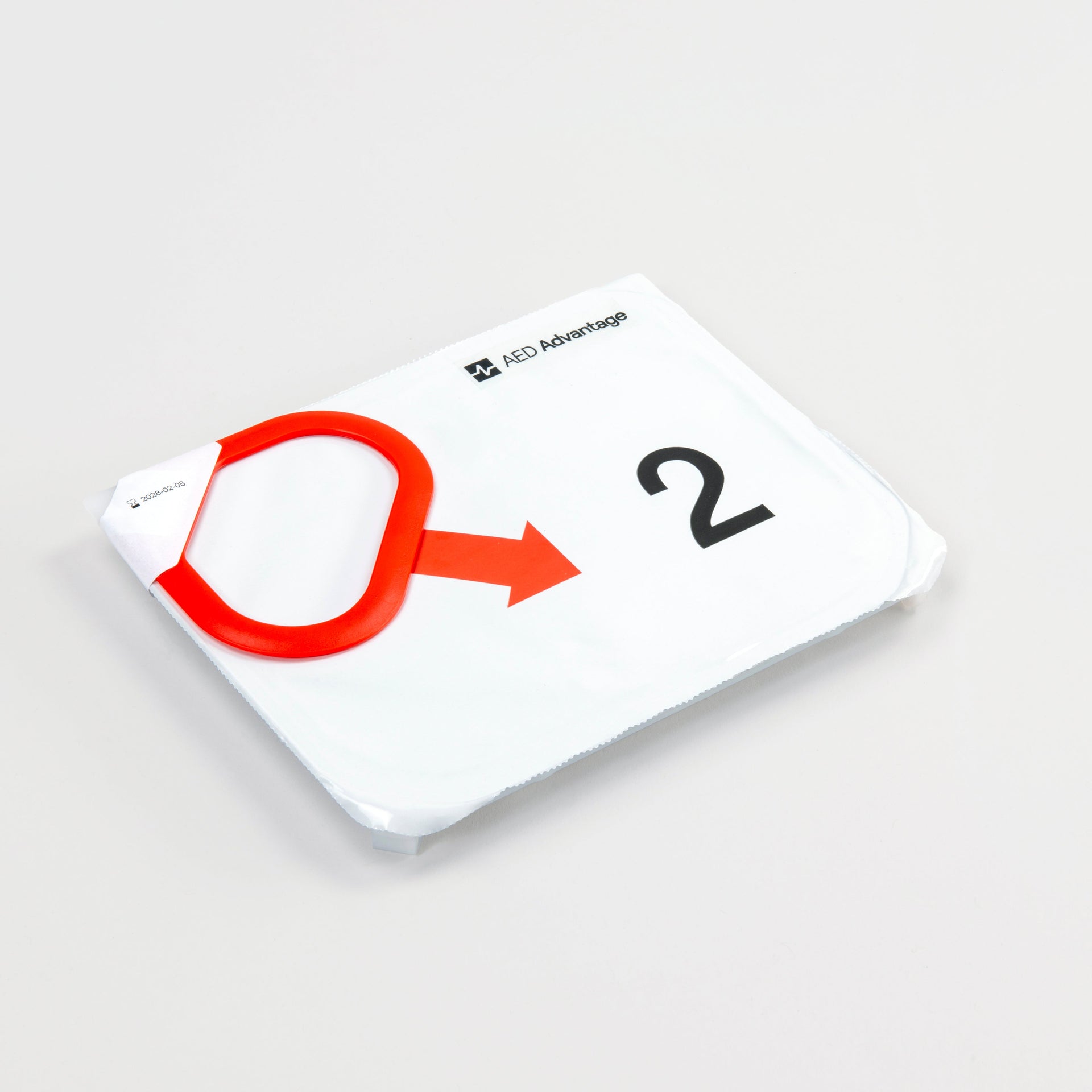 A white rectangular electrode cartridge for the LIFEPAK CR2 defibrillator with a red tab on its top left corner