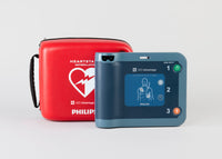 A blue Philips FRx AED displayed with its bright red carry case