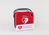 A Philips OnSite AED in a bright red carry case displayed in a white metal wall mount bracket
